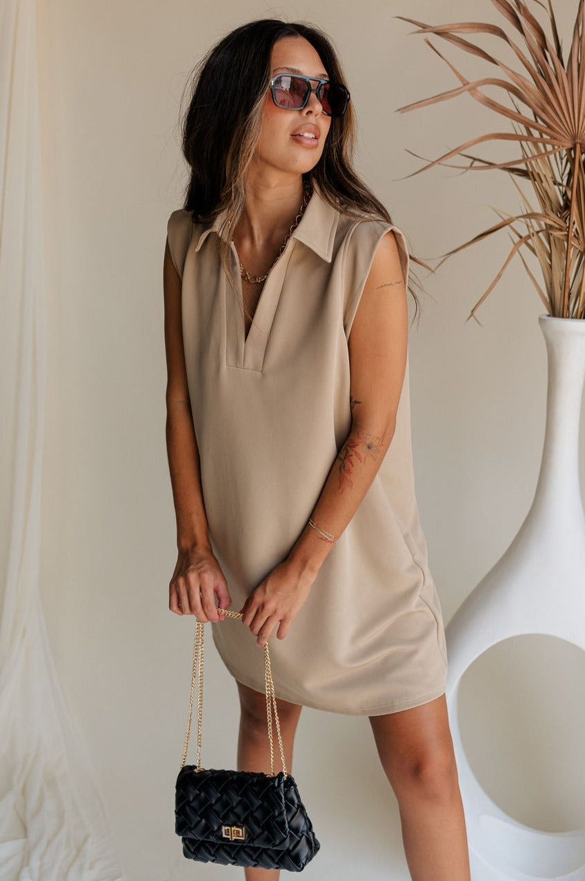front view of female model wearing the Lena Taupe Ribbed V-Neckline Mini Dress which features Light Taupe Ribbed Fabric, Two Side Pockets, V Neckline with Collar and Sleeveless
