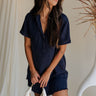 front view of female model wearing the Leighton Navy Fray Short Sleeve Mini Dress which featuresNavy Blue Tencel Fabric, Fray Hem Details, Mini Length, Quarter Button-Up Closure, Collared Neckline, Short Sleeves and Left Front Chest Pocket 