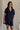front view of female model wearing the Leighton Navy Fray Short Sleeve Mini Dress which featuresNavy Blue Tencel Fabric, Fray Hem Details, Mini Length, Quarter Button-Up Closure, Collared Neckline, Short Sleeves and Left Front Chest Pocket