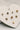 close up view of the Lucia Gold Starburst Stud Earring Set which features set of stud earrings include stars, starburst, clear studs and gold beads