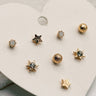 close up view of the Lucia Gold Starburst Stud Earring Set which features set of stud earrings include stars, starburst, clear studs and gold beads