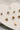 close up view of the Lucia Gold Starburst Stud Earring Set which features set of stud earrings include stars, starburst, clear studs and gold beads