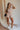 Full body view of model wearing Autumn Taupe Romper. This romper has a 3 quarter zip and collared neckline, tie on waist and thick waistband.