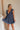 Full body view of model wearing Savannah Navy Floral Mini Dress. This is a navy floral mini dress with ruffle upper details.