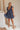Full body view of model wearing Savannah Navy Floral Mini Dress. This is a navy floral mini dress with ruffle upper details.