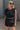 Close up view of model wearing Tatum Mini Skirt in black. This is a mini skirt with a drawstring waistband, bubble hem, and mini length.