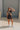 Full body view of model wearing Tatum Mini Skirt in espresso. This is a mini skirt with a drawstring waistband, bubble hem, and mini length.