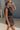 Side view of model wearing Tatum Mini Skirt in espresso. This is a mini skirt with a drawstring waistband, bubble hem, and mini length.