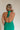 Back view of model wearing Madelyn Green Halter Maxi Dress. This is a green maxi dress with a halter criss cross neckline.