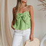Close up of model wearing Kamryn Green Bow Tank. This is a light green tank with bow detail, sleeveless. 