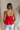 Back view of model wearing Kendall Bow Tank in red. This is a peplum tank with bow detail coming in either red or maroon.