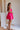Side view of model wearing Carly Hot Pink Mini Dress. This is a hot pink mini dress, corset looking top and sleeveless.