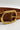 Image shows close-up of buckle on the Marcy Brown Embroidered Belt against a white background. Belt has brown faux leather with brown embroidery and a gold oval buckle.