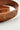 Image shows close-up of embroidery on the Marcy Brown Embroidered Belt against a white background. Belt has brown faux leather with brown embroidery and a gold oval buckle.