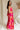 Full body side view of female model wearing the Luna Orange & Fuchsia Floral Maxi Dress which features Fuchsia, Red Orange and Linen Floral Print, Linen Lining, Strapless, Back Tie Detail and Maxi Length