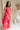 Full body side view of female model wearing the Luna Orange & Fuchsia Floral Maxi Dress which features Fuchsia, Red Orange and Linen Floral Print, Linen Lining, Strapless, Back Tie Detail and Maxi Length