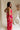 frontal side view of female model wearing the Luna Orange & Fuchsia Floral Maxi Dress which features Fuchsia, Red Orange and Linen Floral Print, Linen Lining, Strapless, Back Tie Detail and Maxi Length