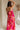 back view of female model wearing the Luna Orange & Fuchsia Floral Maxi Dress which features Fuchsia, Red Orange and Linen Floral Print, Linen Lining, Strapless, Back Tie Detail and Maxi Length