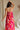 back  view of female model wearing the Luna Orange & Fuchsia Floral Maxi Dress which features Fuchsia, Red Orange and Linen Floral Print, Linen Lining, Strapless, Back Tie Detail and Maxi Length