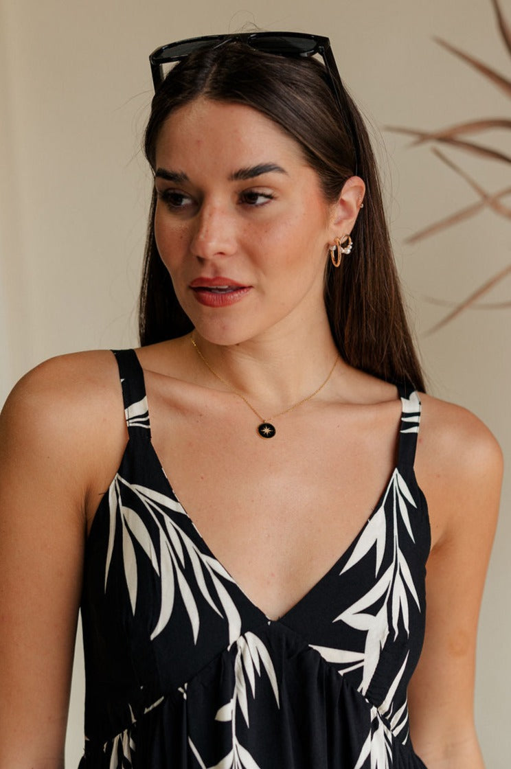 front view of female model wearing the Julia Black & Gold Starburst Necklace which features adjustable gold chain link with a black medallion and gold star design