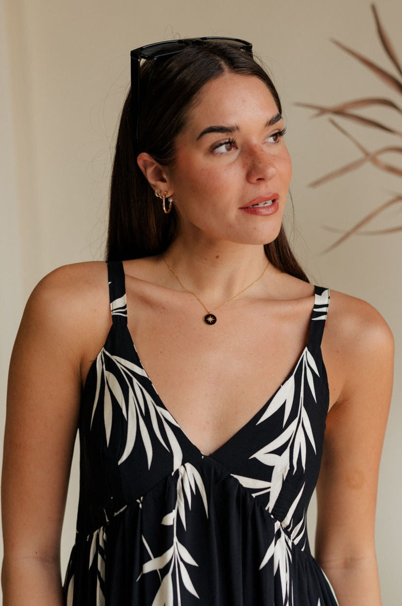 front view of female model wearing the Julia Black & Gold Starburst Necklace which features adjustable gold chain link with a black medallion and gold star design