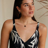 front view of female model wearing the Julia Black & Gold Starburst Necklace which features adjustable gold chain link with a black medallion and gold star design