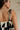close up back view of female model wearing the Lila Black & Cream Tie Straps Romper which features Black and White Geometric Pattern, White Shorts Lining, Two Side Pockets, Ruffle Upper, Square Neckline and Tie Straps
