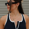 Front view of female model wearing the Luna Black & Gold Crescent Necklace which features adjustable gold chain link with a black medallion and gold moon design