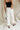 back view of female model wearing the Poppy White Buttoned Wide Leg Pants which features White Lightweight Fabric, Cropped Wide Leg, Front Zipper with Button Closure, Two Front Pockets with Monochrome Buttons and Two Back Pockets