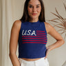 Upper body front view of female model wearing the USA Navy Knit Flag Tank Top that has navy knit fabric, a stitched flag with red stripes and white USA text, and a round neck.