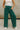 Close up view of model wearing the Emerson Pants in green. These are comfy pants with a ruched waistband, cargo pant look, comes in either black or green.