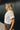 Close up of model wearing the Millie Crochet Short Sleeve Sweater in white. This is a cropped sweater top, crochet, short sleeve, comes in either black, white, or khaki.