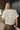 Close up back view of model wearing the Millie Crochet Short Sleeve Sweater in white. This is a cropped sweater top, crochet, short sleeve, comes in either black, white, or khaki.