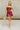 Full body front view of female model wearing the Anya Burgundy Faux-Leather Strapless Dress that has burgundy faux-leather fabric, a strapless neck, and mini-length hem.