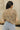 Close up back view of model wearing the Millie Crochet Short Sleeve Sweater in khaki. This is a cropped sweater top, crochet, short sleeve, comes in either black, white, or khaki.