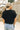 Close up back view of model wearing the Millie Crochet Short Sleeve Sweater in black. This is a cropped sweater top, crochet, short sleeve, comes in either black, white, or khaki.