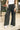 Close up view of model wearing the Emerson Pants in black. These are comfy pants with a ruched waistband, cargo pant look, comes in either black or green.