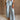 Lower body front view of female model wearing the Greer Wide Legs Jeans that have light wash denim, frayed hems, and a front zipper and button closure