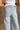 Close-up back view of female model wearing the Greer Wide Legs Jeans that have light wash denim, frayed hems, and a front zipper and button closure