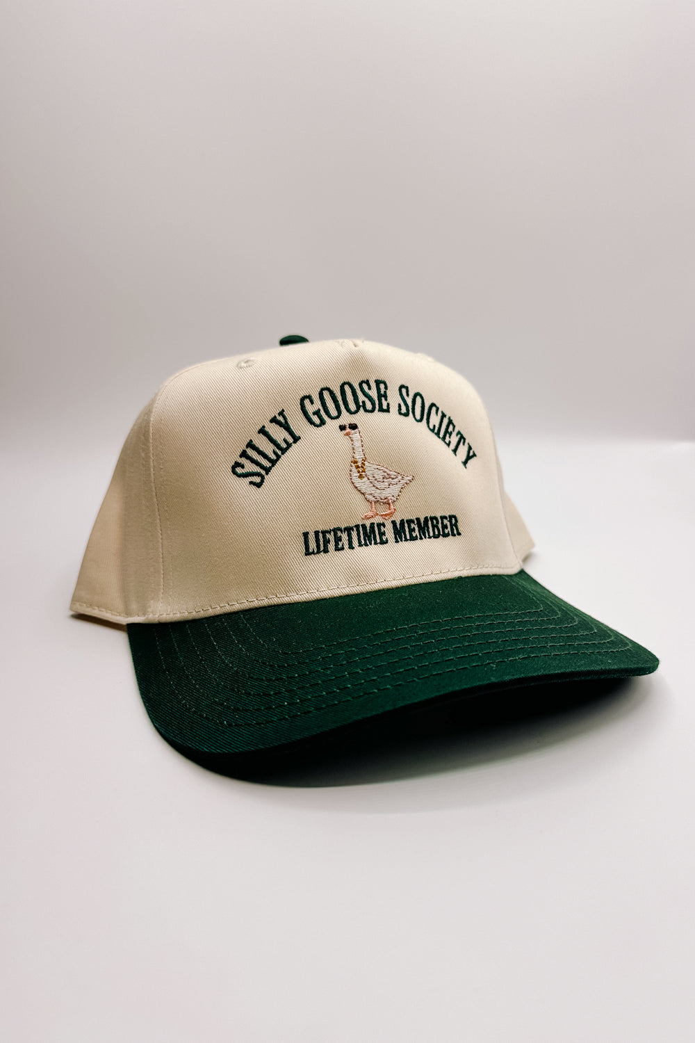 Image shows frontal view of the Silly Goose Society Trucker Hat against a white background.