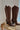 Image shows side view of the Ashton Brown Western Boots, that have dark brown suede material, white piping, black block heels, and western stitching.