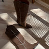 Image shows side and top view of the Ashton Brown Western Boots, that have dark brown suede material, white piping, black block heels, and western stitching.