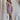 Full body front view of female model wearing the Morgana Sleeveless Bodycon Mini Dress in Tan that has fitted knit fabric, a round neckline, and is sleeveless. 