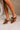 Side view of model's feet; model is wearing the Keira Mocha Bow Mule Heels.