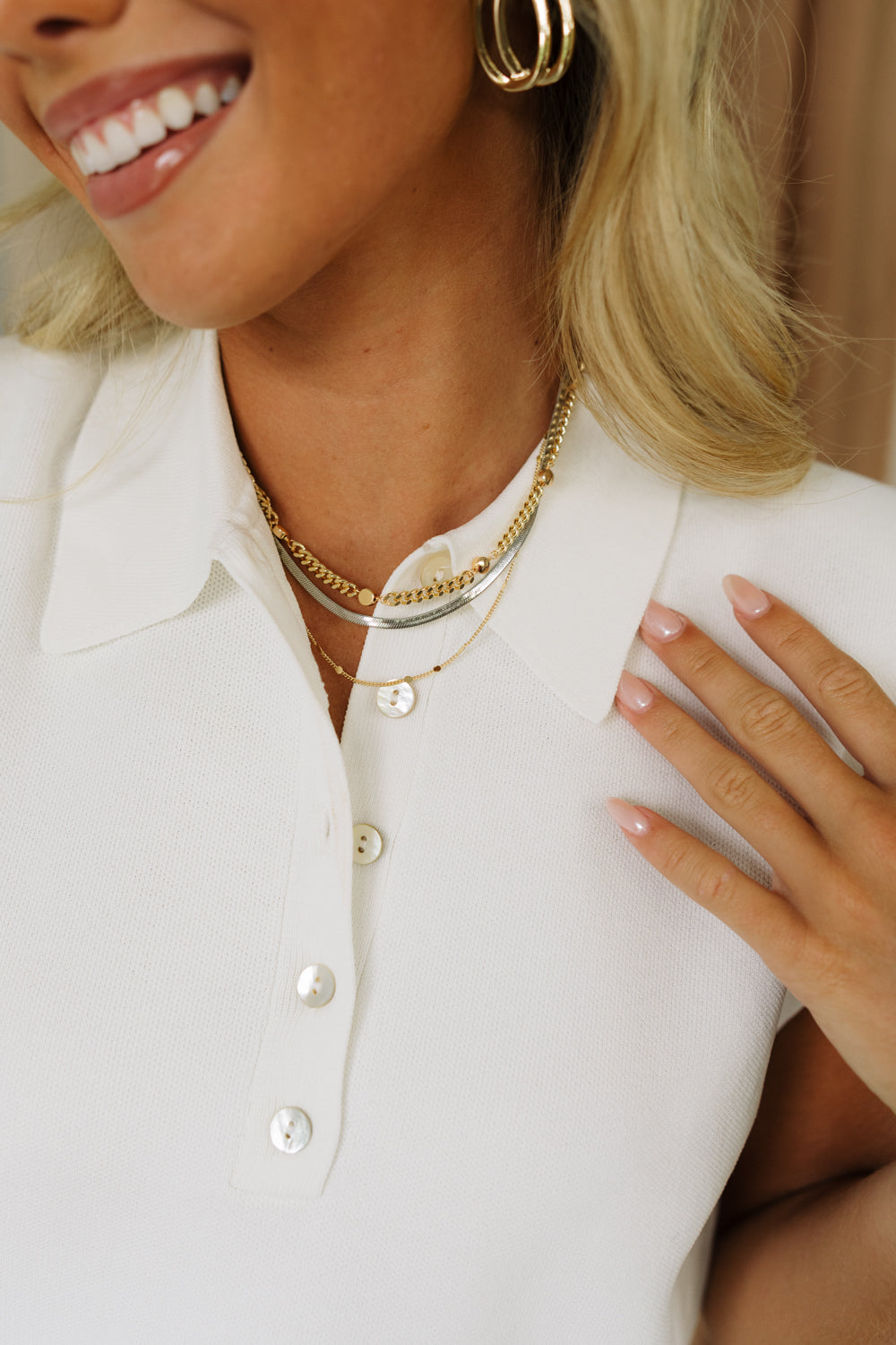 Front view of female model wearing the Alaia Gold and Silver Layered Necklace that has 3 gold and silver chains.