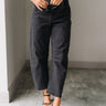 Lower body front view of female model wearing the Rosalind Black Barrel Jeans with a brown tank top and black heels.