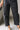 Close-up lower front view of female model wearing the Rosalind Black Barrel Jeans.
