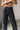 Close up upper body front view of female model wearing the Rosalind Black Barrel Jeans with a brown tank top.