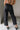 Lower body back view of female model wearing the Rosalind Black Barrel Jeans with a brown tank top and black heels.