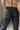 Close-up back view of female model wearing the Rosalind Black Barrel Jeans with a brown tank top and black heels.